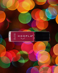 Bottle of Sangria - Clean Nail Polish by HOOPLA in a rich berry color, set against a vibrant, colorful bokeh background for a clean beauty nail polish presentation.