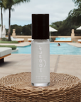 Bottle of Angelic Arrow - Clean Nail Polish in a neutral shade placed on a woven surface with a poolside background, highlighting a clean beauty and nail polish theme.