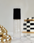 Mini Pearl - Clean Nail Polish bottle with a pearlescent white shade next to a pearl necklace and a black and white checkered box, highlighting clean beauty and nail polish elegance.