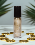Gold Foil - Clean Nail Polish bottle with a shimmering gold shade, surrounded by gold coins and green palm leaves in the background, showcasing a clean beauty nail treatment.