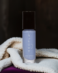 Bottle of M+M - Clean Nail Polish with light purple shade standing on soft textured fabric against a dark background, showcasing clean beauty and vegan nail polish qualities.