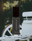 Bottle of Diesel - Clean Nail Polish in sleek black packaging with white text, placed against an outdoor background featuring vintage white furniture and a bicycle wheel.
